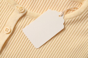 Cardboard tag on beige garment, top view