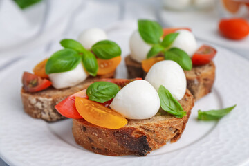 Tasty sandwiches with mozzarella cheese, tomatoes and basil on white table, closeup