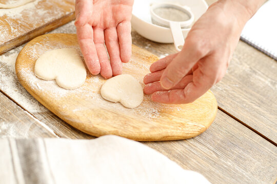 Making Heart Shaped Cookies for Loves Day. Close-up of male hands. Baking concept.