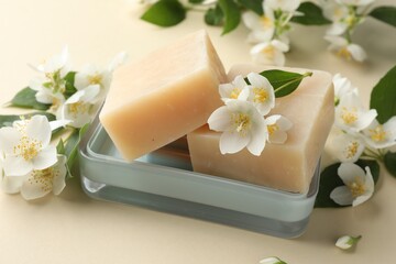 Soap bars and jasmine flowers on beige background, closeup