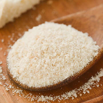 Homemade crispy fine bread crumbs on wooden spoon (Selective Focus, Focus in the middle of the image)
