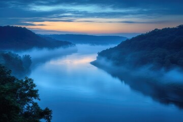Fototapeta premium Serene river flowing through hills, blanketed in ethereal mist under a vibrant sky, painted with the colors of dusk or dawn.