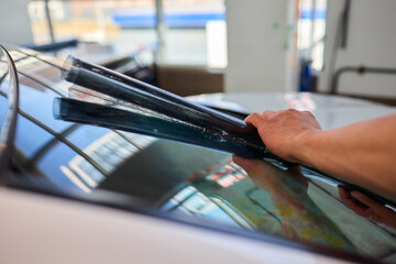 The Professional Windshield Tinting Process Conducted in a Modern Auto Showroom Environment