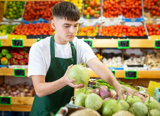 Portrait of a hardworking guy seller working in a vegetable store near the counter