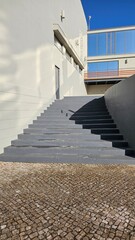 Modern grey concrete stairs with minimal design and blue sky background