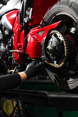 Chain tensioning at motorcycle maintenance service. Motorcycle chain maintenance is essential for...