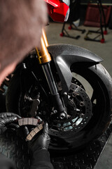 Front Brake Pad Replacement on Red Sport Motorcycle. Front brake pads are inspected and swapped out...