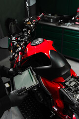 Mechanic performing system diagnostics via tablet. Motorcycle system diagnostic, scanning for...