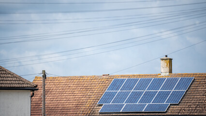 Residential chimney roof with slanted solar panel capturing renewable sunlight energy