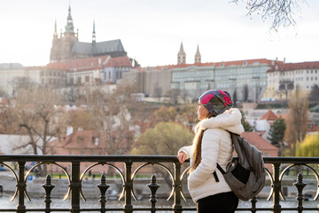 Mujer turista disfrutando de una caminata por la rivera de la ciudad de Praga, al atardecer	