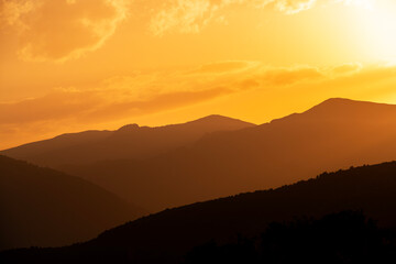 Beautiful sunset over the silhouette  mountains.