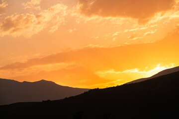 Beautiful sunset over the silhouette  mountains.