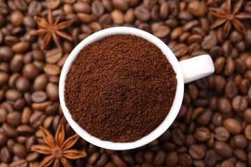 Cup with instant coffee powder and star anise on beans, top view