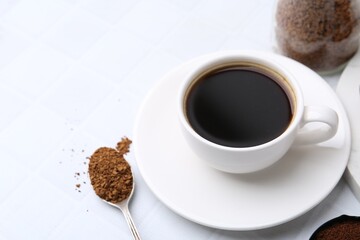 Cup of aromatic coffee and granulated instant coffee on white table, closeup. Space for text