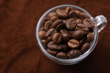 Cup of roasted coffee beans on powder, above view