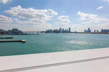 View of city with towers and skyscrapers from Saadiyat Island in Abu Dhabi, United Arab Emirates. View from water surface. High quality photo