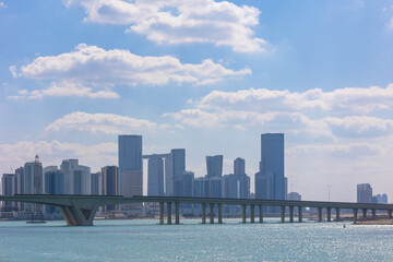 View of city with towers and skyscrapers from Saadiyat Island in Abu Dhabi, United Arab Emirates. View from water surface. High quality photo