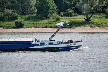 Cargo ship Natasja on the Rhine with bow wave and crew cabin downstream