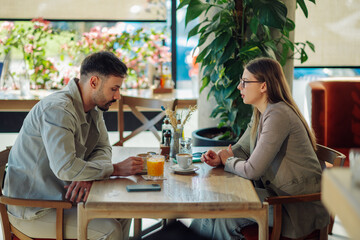 Colleagues discussing business strategy during lunch break in cafe