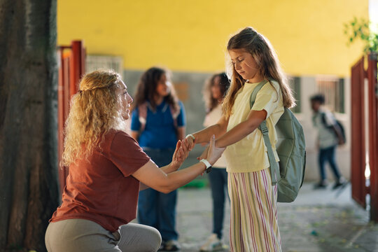 Mother encouraging daughter on first day back to school