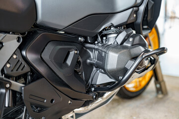 Detailed view of motorcycle engine components in a garage setting during daylight hours
