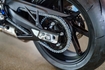 Detailed view of a motorcycle chain and rear wheel showing the mechanics and design in a workshop...