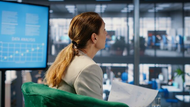 Multiethnic business team collaborating on company strategy, applying executive skills and foresight to achieve growth. Planning future investments through data analysis and research. Camera B.