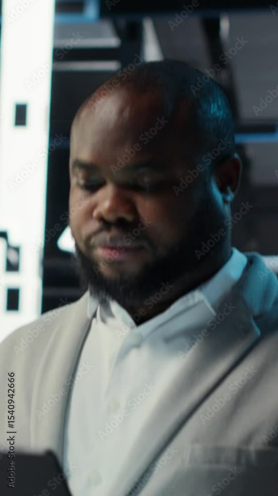 Poster vertical video server room technician doing troubleshooting using tablet to prevent downtime. it exp