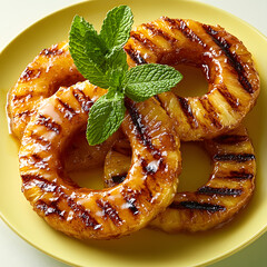 Grilled pineapple rings with mint on pastel yellow plate