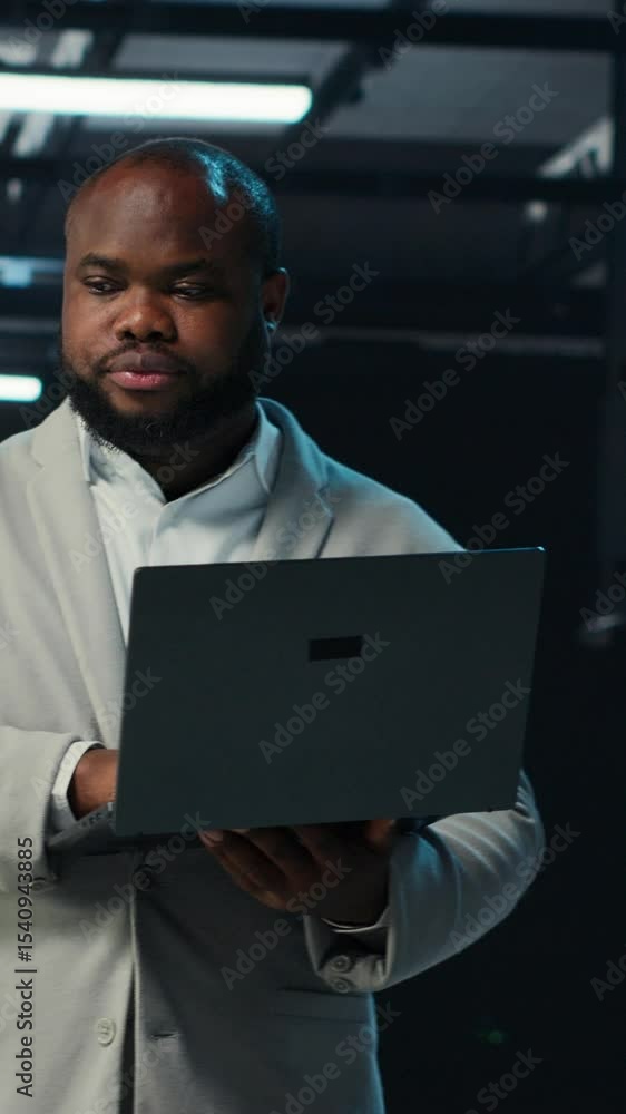 Poster vertical video data center engineer coding on laptop, doing software updates for mainframes. server 