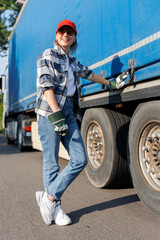 Portrait young adult smiling woman truck driver secures cargo tarp trailer truck  cargo vehicle. Female person girl professional job career working driving freight engine lorry. Logistics industry