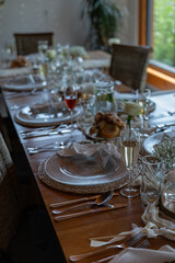 A prepared table for wedding guests with plates, glasses, and decorations. 