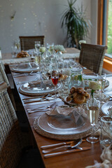 A prepared table for wedding guests with plates, glasses, and decorations. 