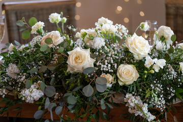 Decorative white rose blossoms in an arrangement, captured in detail at the wedding table.
