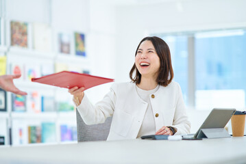 仕事中に同僚と会話する女性