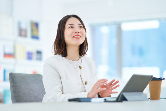 仕事中に同僚と会話する女性