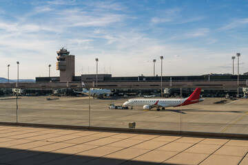 Airplane parked at the gate, seen through a window from inside the airport terminal. Travel and...