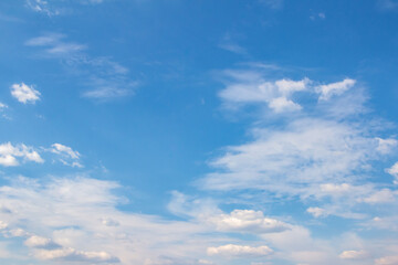 Fototapeta premium Expansive blue sky with soft white clouds scattered throughout, creating a serene atmosphere ideal for backgrounds, design projects, and nature-themed visuals with copy space