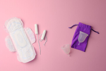 Eco-friendly menstrual cup and other feminine hygiene products on a bright background