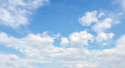 Obraz premium Expansive blue sky filled with fluffy white clouds, creating a serene atmosphere, ideal for backgrounds, designs, and nature-themed projects with ample copy space for text