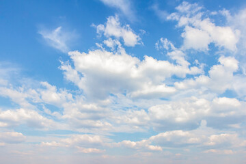 Fototapeta premium Expansive blue sky filled with fluffy white clouds, creating a serene atmosphere, perfect for backgrounds or design projects featuring natural elements and tranquility