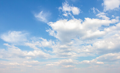 Fototapeta premium Expansive blue sky filled with fluffy white clouds, creating a serene atmosphere, perfect for backgrounds or design projects, showcasing natural beauty and tranquility
