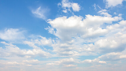 Expansive blue sky filled with fluffy white clouds, creating a serene atmosphere, perfect for backgrounds or design projects featuring natural elements and tranquility