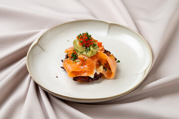 A tempting dish showcases delicate smoked salmon elegantly arranged over a crispy potato pancake, enhanced by fresh herbs and vibrant toppings. The setting is minimalistic and modern