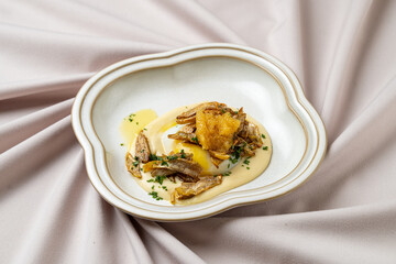 Elegant dish showcasing a creamy base topped with expertly arranged savory elements, presented on a graceful plate. Ideal for gourmet enthusiasts and special occasions