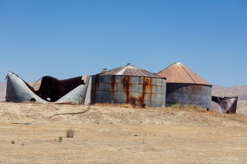 Abandoned and decaying grain silos stand in a field in Carrizo Plain National Monument, California,...