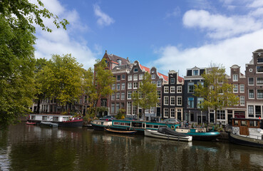 Fototapeta premium Holland, Amsterdam canals with scenic bridges and historic city center, UNESCO World Heritage site.