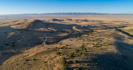 Aerial view of rolling hills and plains in Carrizo Plain National Monument, California, USA. The landscape shows the natural beauty of the region with its unique geological formations.