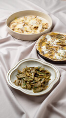 Various delectable dishes are artfully presented on a soft, elegant tablecloth, showcasing vibrant colors and textures, perfect for a family gathering or festive celebration