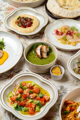 This delightful spread features an array of dishes, from creamy hummus to vibrant salads, all beautifully arranged on a floral tablecloth. Each dish highlights local produce and skillful preparation